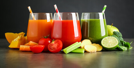 Different tasty juices and fresh ingredients on grey table against black background. Banner design