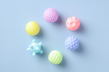 Fototapeta na wymiar Flat lay rubber kid toys balls for bath on blue background. Minimal style.