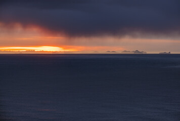 Fototapeta premium Picturesque autumn evening view above Atlantic ocean from Dyrholaey Cape, Vik, South Iceland. Vestmannaeyjar islands weird silhouettes on horizont.