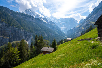 Fototapeta na wymiar amazing landscape of swiss Alps with green meadows and wooden huts in Murren Lauterbrunnen in Switzerland