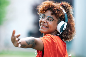 Naklejka premium african american girl with headphones dancing happy