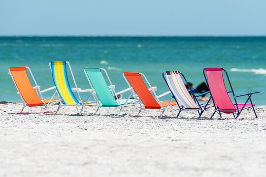 Beach chairs lined up on sand