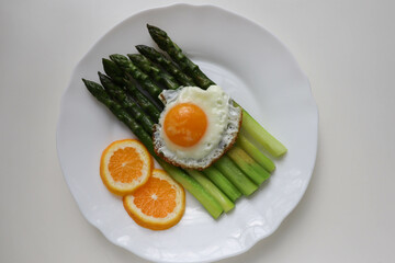 asparagus, lemon and scrambled eggs on a white dish. table setting