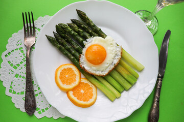 asparagus, lemon and scrambled eggs on a white dish. table setting