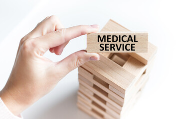 the words MEDICAL SERVICE are written on a wooden cubes structure. Can be used for business, financial, MEDICAL concept. Selective focus.