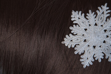 brown hair and snowflake, cold weather hair care concept. Top view, copy space