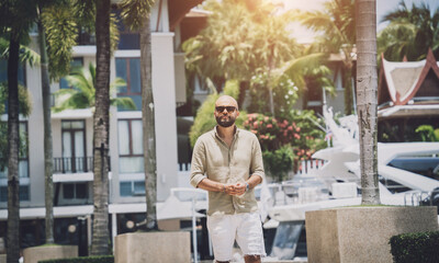 Portrait of a fashion young man posing at marina and yahts background