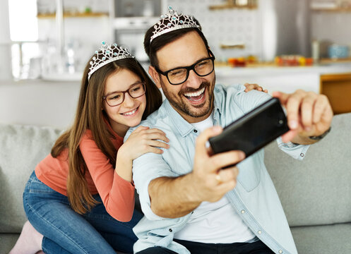 child daughter girl family happy father playing having fun together girl cheerful smiling home princess toy crown bonding love selfie camera mobile phone smartphone photo picture portrait