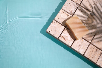 Swimming pool top view background. Water ring and palm shadow on travertine stone
