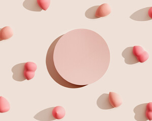 Pink makeup sponges and geometric platform on beige, dark shadow. Mock up Cosmetic background for product presentation or foundation cream. Top view sponges and podium to show cosmetic products