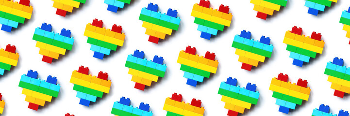 Rainbow color hearts from blocks isolated on white background, geometric pattern from colorful bricks, shape heart from child construction. Love game concept, repeat wide banner