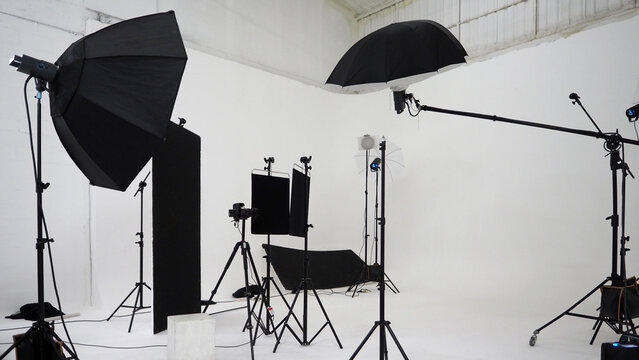 Studio video production lighting set. Behind the scenes shooting production set up by crew team camera and equipment in studio. Video production filming or commercial movie film live streaming online.