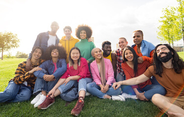 large group of diverse multiracial young people in the park, celebrating life together enjoying...