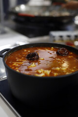 cazuela de legumbres con morcilla en cocina de restaurante