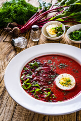 Borsch - beetroots soup with egg on wooden table
