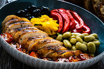 Keto diet - roasted chicken breast and vegetables on wooden table
