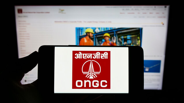 Stuttgart, Germany - 05-21-2022: Person holding cellphone with logo of Oil and Natural Gas Corporation Limited (ONGC) on screen in front of webpage. Focus on phone display.