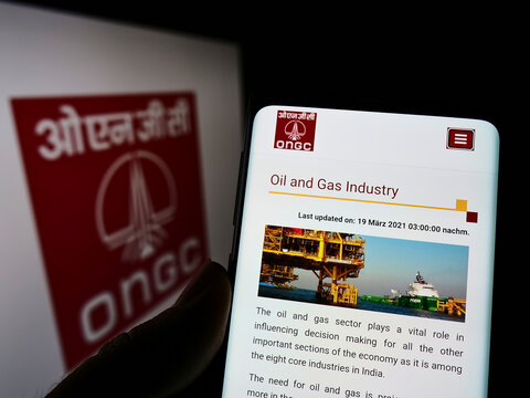Stuttgart, Germany - 05-21-2022: Person holding cellphone with webpage of Oil and Natural Gas Corporation Limited (ONGC) on screen with logo. Focus on center of phone display.