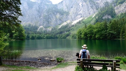 A Man Is Sitting On A Bench In Front Of A Lake