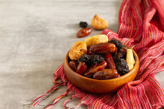 Dried fruits and berries on a wooden bowl . Raisins, nuts, cherries, plums, dried apricots, dates, pineapples, figs, bananas.