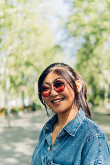 Vertical portrait of a young Japanese woman wearing sunglasses.