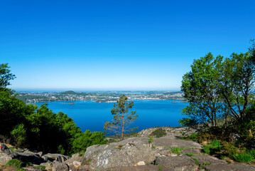 Fototapeta na wymiar A scenic view to still waters of Gandsfjord and Stavanger suburbs coastline from a Lifjel hiking trek, Sandnes, Norway, May 2018
