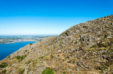 Fototapeta na wymiar Scenic rocky slopes of Lifjel mountain with Gandsfjord and Stavanger on background, Sandnes, Norway, May 2018