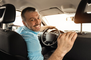 Smiling man driving new car in city © Prostock-studio