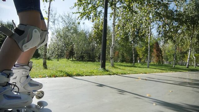 
Girl Rides Roller Skates on the Road. Summer. Slowmotion
