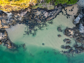 Downward aerial view of beach and crystal clear water