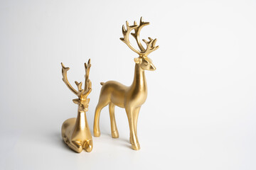 two gold ceramic statuette deer on white
