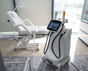 Empty beautician office with white couch and photorejuvenation machine. 