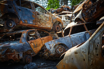 A lot of rusty burnt cars in Irpen, after being shot by the Russian military. Russia's war against Ukraine. Cemetery of destroyed cars of civilians who tried to evacuate from the war zone
