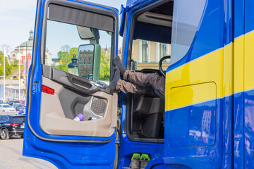 Close up view of truck driver taking rest pause from work bu putting legs on oppen door. Sweden. 
