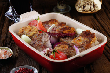   Spanish cuisine. Beef tail with garlic, chili onions. In porcelain forme. Homemade food.