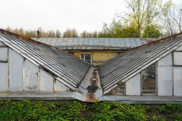 Obraz premium Old abandoned glass greenhouses and farmhouse in countryside