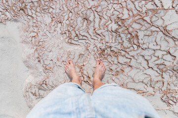 Legs of tourist in travertine pools blue water in Pamukkale Turkey, top view