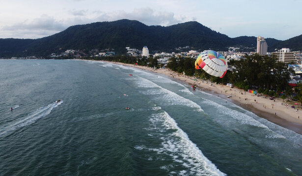 People parasail tied to a boat along Patong beach, Phuket, southern Thailand. The Thai government is accelerating the completely reopen of the country to foreign tourists amid COVID-19 in 2022.