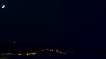 Time lapse of a lunar eclipse setting and the sun rising over the citadel of Calvi in the Balagne region of Corsica