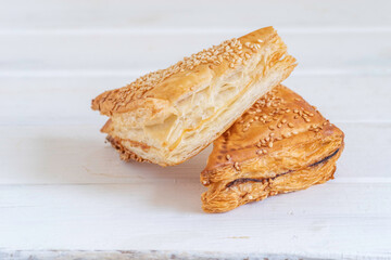 Israeli Savory Cheese Pastry Bourekas on white wooden background.
