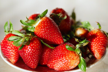 Fresh strawberries in a bowl on wooden table.