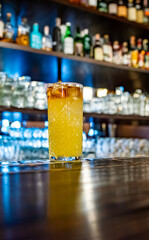 Fresh cocktail with orange at the bar counter in the night club.