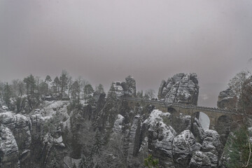 snowy landscape of the Elbsandsteingebirge with bastion bridge (Saxon Switzerland, Germany)