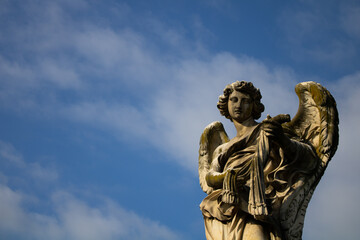 Angel statue with blue sky in background in Rome