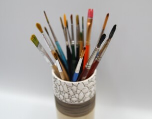 Paint brushes in support. Luxurious glass full of different brushes