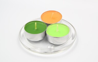 Green and orange colored candles on glass candle holder