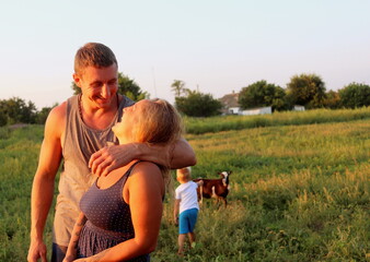 a cute married couple of European appearance smile at each other on a summer evening in nature...