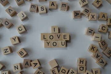 I love you written with wooden cubes surrounded by a bunch of other cubes with letters, expressing feelings towards others