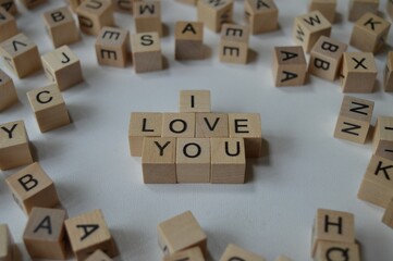 I love you written with wooden cubes surrounded by a bunch of other cubes with letters, expressing feelings towards others