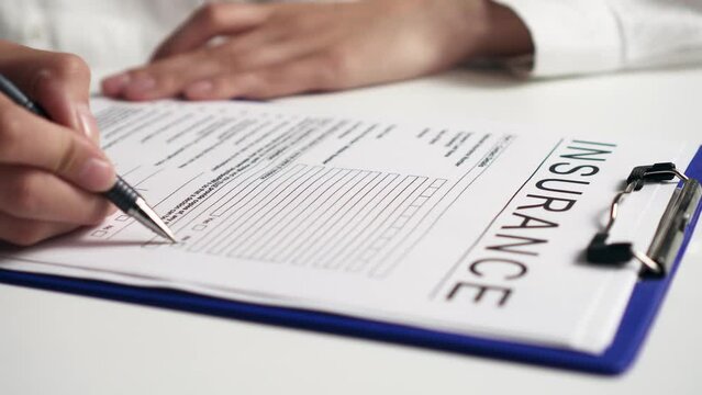 Insurance filling form the agent fills out the health insurance for client to complete the transaction and save life Insurance agent at the workplace drawing up insurance documents. Warranty concept
